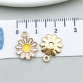 Pair of white enamel daisy flower pendants with gold alloy base shown on measuring tape - Daisy Flower Style
