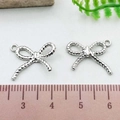Close-up of silver bow pendant charms with rope texture design and scale measurement - Rope Texture Bowknot (21387)