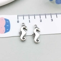 Set of two silver seahorse alloy charms for DIY jewelry making shown with measuring tape - Antique Silver Seahorse Style (17378) / 7*17mm
