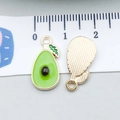 Enamel avocado charm pendant in green and gold finish measured with a white scale ruler - Avocado (11983)