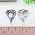 Antique silver heart-shaped angel wings pendant shown with a ruler for size reference - Antique Silver Heart Wing (21421)