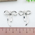 Pair of silver bow-shaped alloy pendants with polished finish for DIY jewelry crafting - Bowknot (21393)
