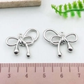 Pair of shiny silver bow-shaped alloy pendants measuring 20mm for DIY jewelry making - Entwined Bowknot (21405)