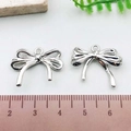 Polished silver ribbon bow pendant for DIY jewelry, measuring 2.5cm with top loop - Hollow Bowknot (21407)