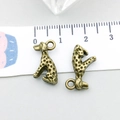 Nahaufnahme eines antiken Bronze-Leopardenanhängers mit Textur auf einem Maßstab - Antik-Bronze Gefleckter Sitzender Hund 16*9mm (20569)