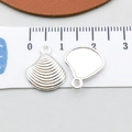 Macro shot of silver shell pendant with radial texture and ring on measuring tape - Bright Silver Shell (20684)