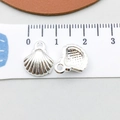 Detailed close-up of small silver shell charm pendant showing front and back textures - Bright Silver Shell (20687)