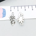 Antique silver daisy pendant with textured petals and stem, shown on scale - Antique Silver Small Flower (15761)