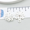 Macro view of silver sunflower charms on a measuring tape showing 1.5cm diameter - Hollow Flower (20444)