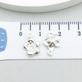 Macro shot of silver sunflower pendants measured with a ruler for 10mm DIY jewelry crafting - Plum Blossom (20446)