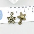 Detailed macro view of bronze flower pendant with scale showing 13mm diameter size - Small Flower (20482)
