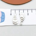 Silver shell-shaped charms for jewelry making shown with tape measure for size - Bright Silver Conch (20703)