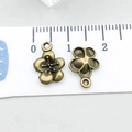 Antique bronze plum blossom alloy charms showing front and back views on a ruler - Plum Blossom (20494)