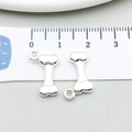 Silver bone-shaped metal pendant charm for DIY jewelry making shown with size ruler - Bright Silver Bone (20542)