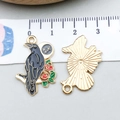 Detailed macro view of black enamel raven and red rose charm with metallic gold backing - Black Enamel Flower Raven (16643)