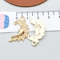 Detailed macro view of gold alloy crescent moon and leaf charms with engraved patterns - KC Gold Moon (18238)