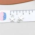 Detail view of two silver star charms on a measuring ruler for DIY jewelry making - Antique Silver Small Star (5812)