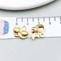 Detailed view of two cat-shaped gold alloy pendants with measurement on a ruler - Curled Cat Style (18282)