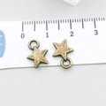 Close-up of 10mm antique bronze star charm with bail on a white measuring ruler scale - Antique Bronze Star (1540)
