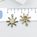 Bronze celestial sun alloy charm for DIY jewelry making shown next to a ruler for size - Antique Bronze Sun (20863)