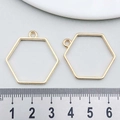 Close-up of golden geometric hexagon frame pendants with measurement ruler for DIY jewelry - Hexagonal Frame