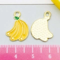 Détail du pendentif banane en émail jaune avec cadre doré à côté d'une règle graduée - Banane en Émail Jaune (22180)