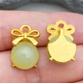 Close-up of green glass bow pendant showing front detail and gold metal backing - Light Green Lampwork Bowknot (22205) / 16*11mm