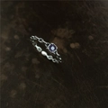 Détail macro d'une bague chaîne argentée avec une pierre de zircone violette sertie - Violet