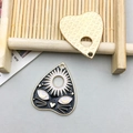Macro-opname van zwarte emaille hangers met zon en kattengezicht en gouden achterzijde - Mysterieuze Kattengezicht Stijl / Zwart Gouden Rand