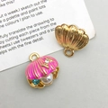 Detail eines rosa Emaille Muschel-Anhängers mit Perle und Kristall auf Metallbasis - Fuchsia