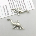 Close-up of two dinosaur shaped alloy charms with detailed carving for DIY jewelry making - Antique Silver Brachiosaurus Style (2381)