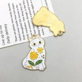 Détail macro d'un pendentif chat en émail blanc avec motifs floraux et dos en métal doré - Petit / Blanc KC Gold (Chat Floral en Émail)