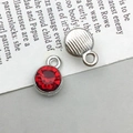 Macro detail of silver alloy round pendants with faceted red rhinestones for DIY jewelry - Silver January Style (13493)