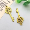 Macro detail of antique gold rose key pendant with embossed texture for DIY jewelry - 27x10mm / Antique Gold Vintage Key Style (11387)