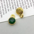 Antique gold alloy round charm with green faceted stone and textured metal back - May-Green