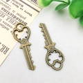 Set of two vintage bronze alloy key pendants with ornate hollowed flower design for DIY jewelry - 13x37mm / Vintage Key Style (931)