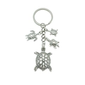 Silver hollow turtle keychain featuring one large and three small sea turtle pendants - Antique Silver