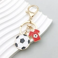 Golden soccer keychain featuring a red jersey pendant and black white football charm - Football Jersey Style (ER771)
