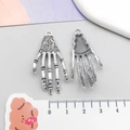 Vista macro dettagliata di ciondoli a mano scheletrica in argento vintage con trama ossea - Stile Mano di Teschio Argento Antico (4197)