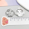 Dettaglio macro di ciondoli a teschio in argento antico con righello che mostra 25mm - Stile Teschio Argento Antico (3166)