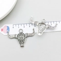 Detailed macro view of vintage silver bull skull pendants with hollow design and size scale - Antique Silver Hollow Bull Head (18709)