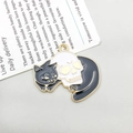 Enamel black cat on white skull pendant charm with golden metal edges and details - Black Cat Lying by Skull (18142)