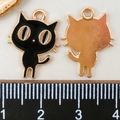 Détail d'un pendentif chat en émail avec yeux dorés et règle pour la taille de 2cm - Chat Émaillé Noir (11026)