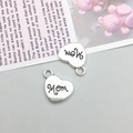 Macro shot of two heart-shaped Mom charms for DIY necklaces with vintage alloy finish - Antique Silver Heart MOM Letters (15729)