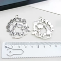 Macro shot of antique silver Alice fairy tale charms with double-sided hollow details - Round Alice Forest Pendant (2504)