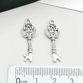 Detail view of retro silver key pendants with ornate hollow patterns and size scale - Small Key Pendant (3112)