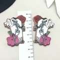 Makroaufnahme von Halloween-Skelett-Anhängern aus Acryl mit Lineal für Größenangaben - Skelett Rose Grabstein Stil (19313)