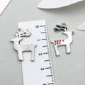 Detail view of two reindeer alloy pendants with measurement ruler on flat grey surface - White Enamel Christmas Elk-19650