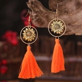 Bohemian gouden zonnebloem oorbellen met lange oranje kwastjes op rustiek hout - Heloranje