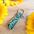 Détail de porte-clés en cuir turquoise vintage avec breloque tournesol et gaufrage floral - Style Pendentif Tournesol à Main (4)